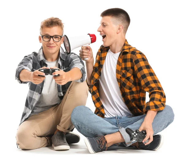 Teenage boys with video game controllers and megaphone on white background — Stock Photo, Image