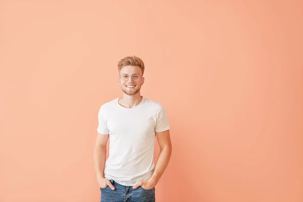 Mann in stylischem T-Shirt auf farbigem Hintergrund — Stockfoto
