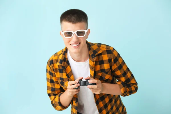 Мальчик-подросток играет в видеоигры на цветном фоне — стоковое фото