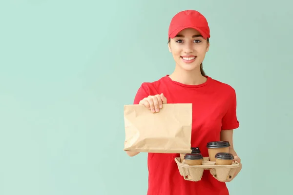 Female worker of food delivery service on color background — Stock Photo, Image