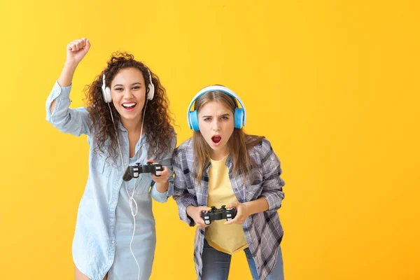 Adolescentes jugando videojuego en el fondo de color —  Fotos de Stock