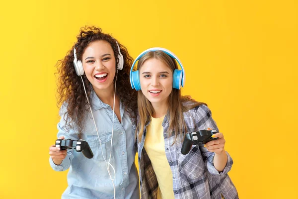 Підлітки грають у відеогру на кольоровому фоні — стокове фото