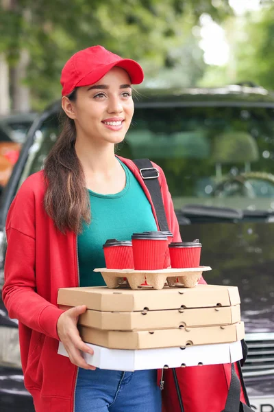 Vrouwelijke werknemer van Food delivery service in de buurt van Car buitenshuis — Stockfoto