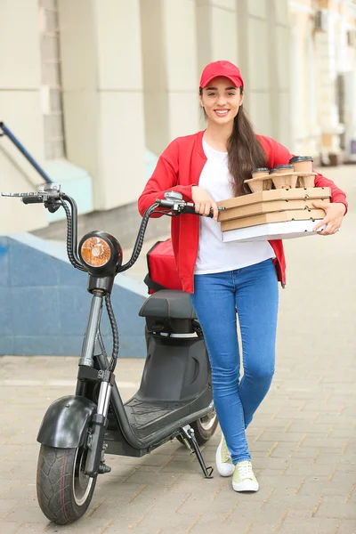 Trabalhadora do serviço de entrega de alimentos perto de scooter ao ar livre — Fotografia de Stock