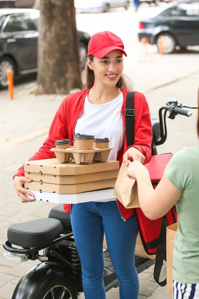 Woman taking order from courier of food delivery service outdoors — Stock Photo, Image