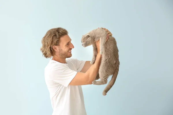 Man with cute funny cat on light background — Stock Photo, Image