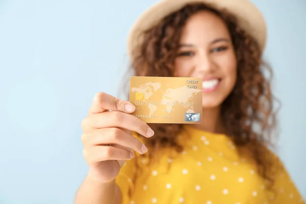 Happy African-American woman with credit card on light color background — Stock Photo, Image