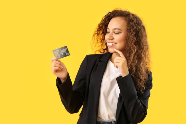 Hermosa mujer afroamericana con tarjeta de crédito en el fondo de color — Foto de Stock