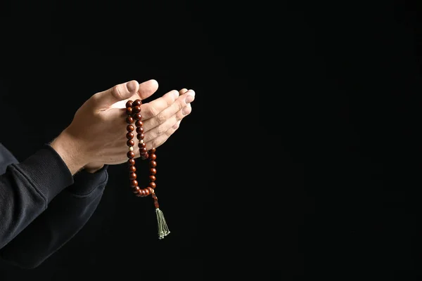 Religious young man praying to God on dark background — Stock Photo, Image