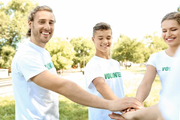 Grupo de voluntários unindo as mãos ao ar livre — Fotografia de Stock