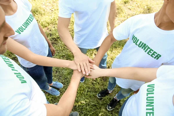Grupo de voluntarios poniendo las manos juntas al aire libre — Foto de Stock