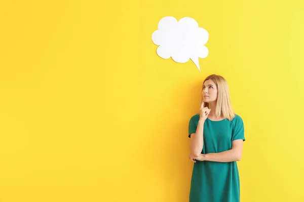 Thoughtful woman with speech bubble on color background — Stock Photo, Image