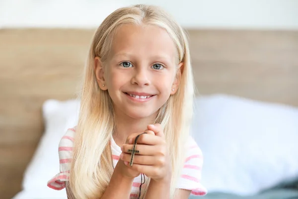 Little girl with cross at home — Stock Photo, Image