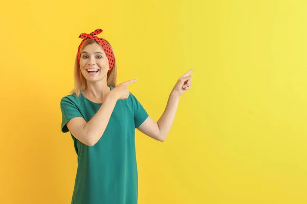 Stylish beautiful woman pointing at something on color background — Stock Photo, Image