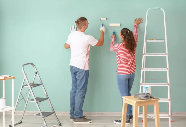 Feliz jovem casal parede pintura em sua nova casa — Fotografia de Stock