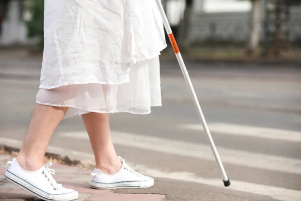 Слепая зрелая женщина переходит дорогу — стоковое фото