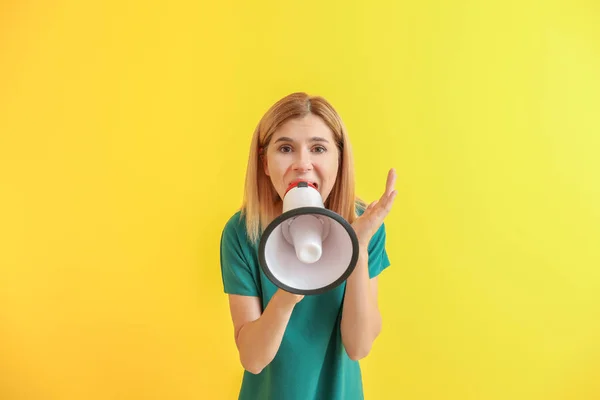 Screaming woman with megaphone on color background — Stock Photo, Image