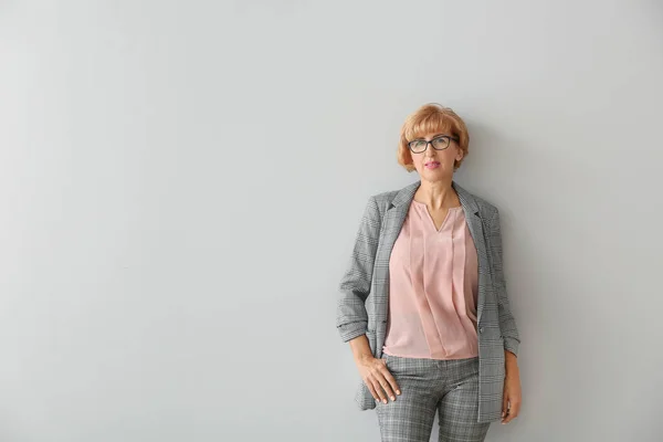 Portrait of beautiful middle-aged woman on light background — Stock Photo, Image