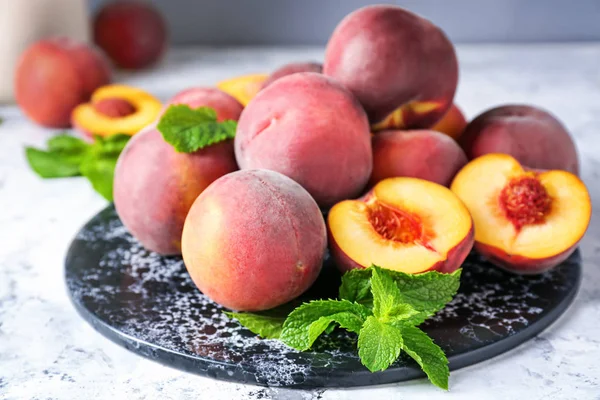 Дошка зі смачними персиками на столі — стокове фото