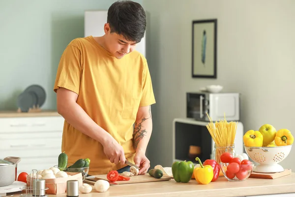 Handsome Asian man cooking in kitchen — Stock Photo, Image