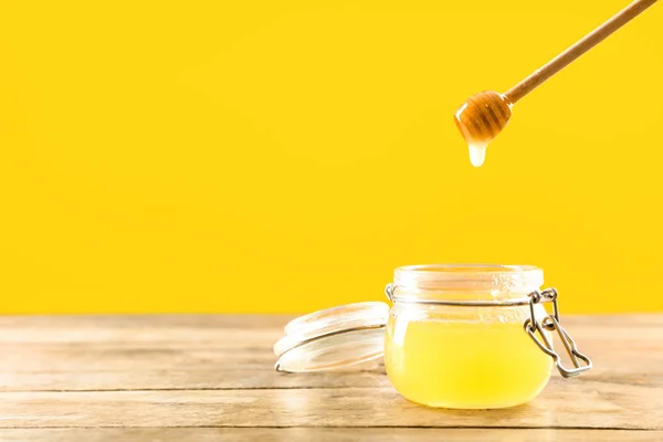 Jar and dipper with tasty honey on color background — Stock Photo, Image