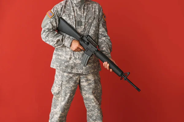 Soldier with assault rifle on color background — Stock Photo, Image