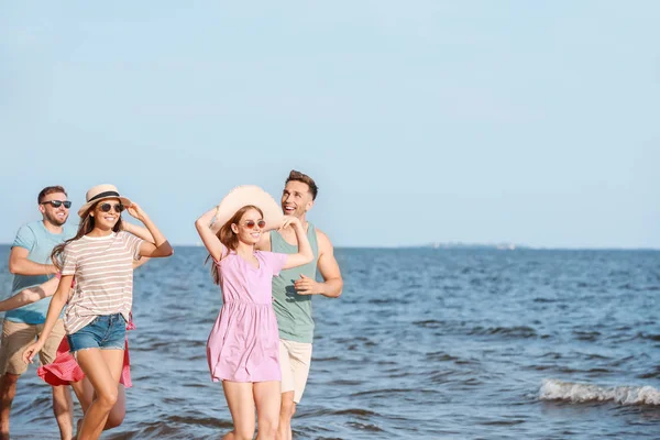 Amigos felices corriendo en la playa del mar en el resort — Foto de Stock