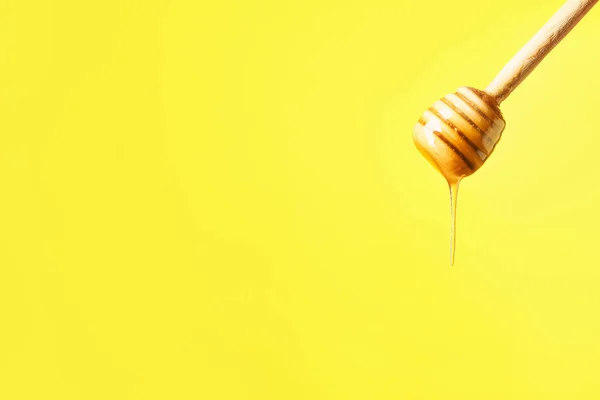 Dipper with tasty honey on color background — Stock Photo, Image