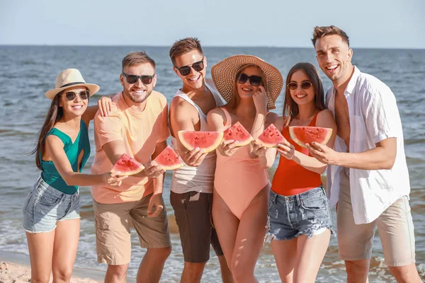 Happy friends eating watermelon on sea beach at resort — Stock Photo, Image