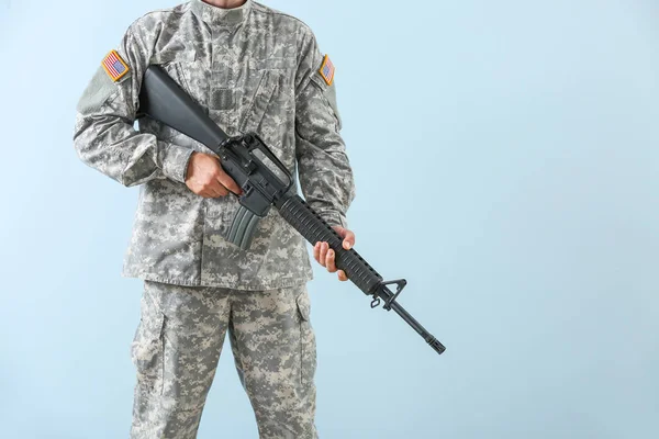 Soldier with assault rifle on color background — Stock Photo, Image