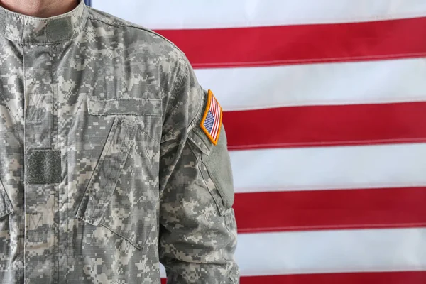 Soldier in camouflage with national flag of USA on background, closeup — Stock Photo, Image