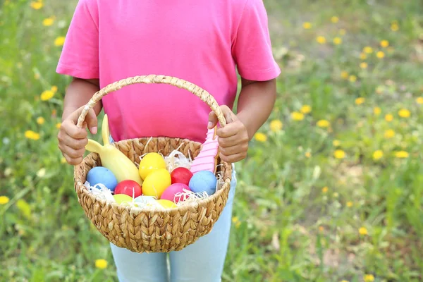 African-American girl with basket of Easter eggs in park, closeup — Stock Photo, Image