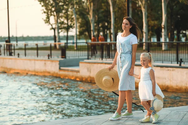 Mutlu anne ve nehir kenarında onun küçük kızı