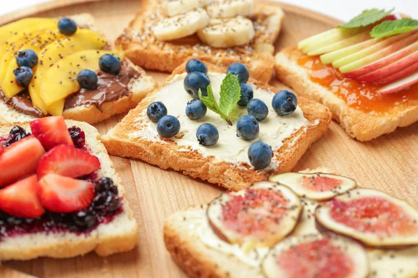 Different tasty sandwiches on board, closeup — Stock Photo, Image