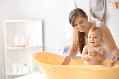 Anne evde onu sevimli küçük bebek banyo