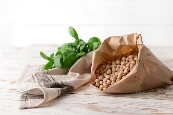 Paper bag with raw chickpea on table