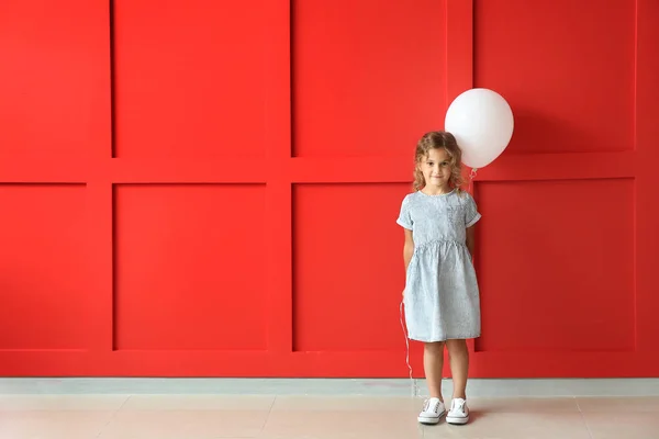 Niña con globo cerca de la pared de color — Foto de Stock