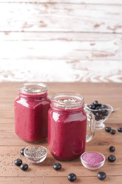 Mason jars of acai smoothie on wooden table — Stock Photo, Image