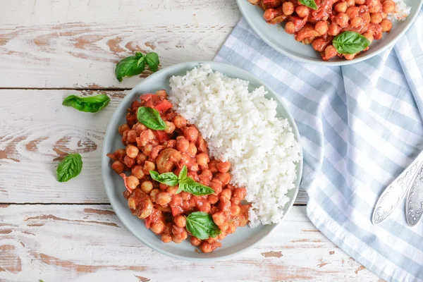 Domates soslu lezzetli nohut ve masada haşlanmış pirinç ile Tabak