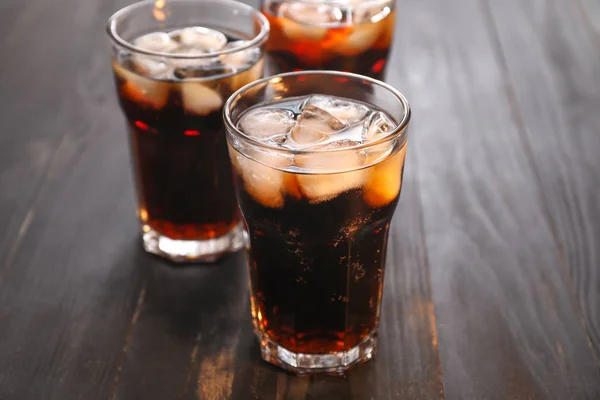 Glasses of cold cola on wooden table — Stock Photo, Image
