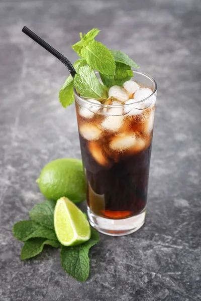 Glass of cold cola and lime on grey table — Stock Photo, Image