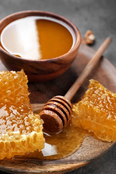 Schüssel mit Honig, Waben und Löffel auf dem Tisch — Stockfoto