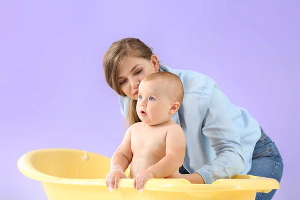 어머니 목욕 그녀의 귀여운 아기 에 색상 배경 — 스톡 사진