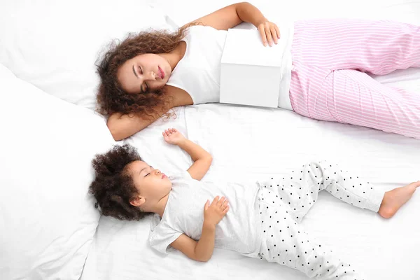 Little African-American girl with mother sleeping in bed — Stock Photo, Image