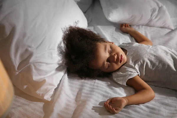 Pequena menina afro-americana dormindo na cama à noite — Fotografia de Stock