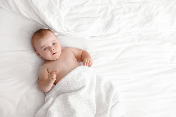 Schattige kleine baby na het Baden op bed liggen — Stockfoto