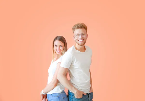 Par i snygga t-shirts på färg bakgrund — Stockfoto