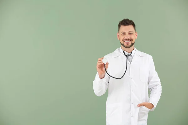 Médico varón con estetoscopio sobre fondo de color —  Fotos de Stock