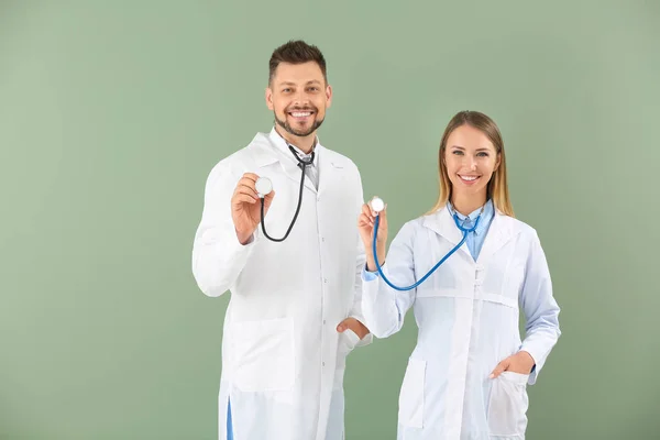 Dokter pria dan wanita dengan stetoskop di latar belakang warna — Stok Foto