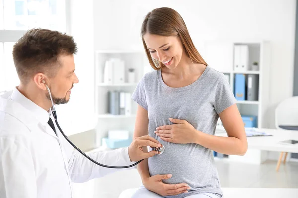 Médico examinando a mujer embarazada en clínica — Foto de Stock